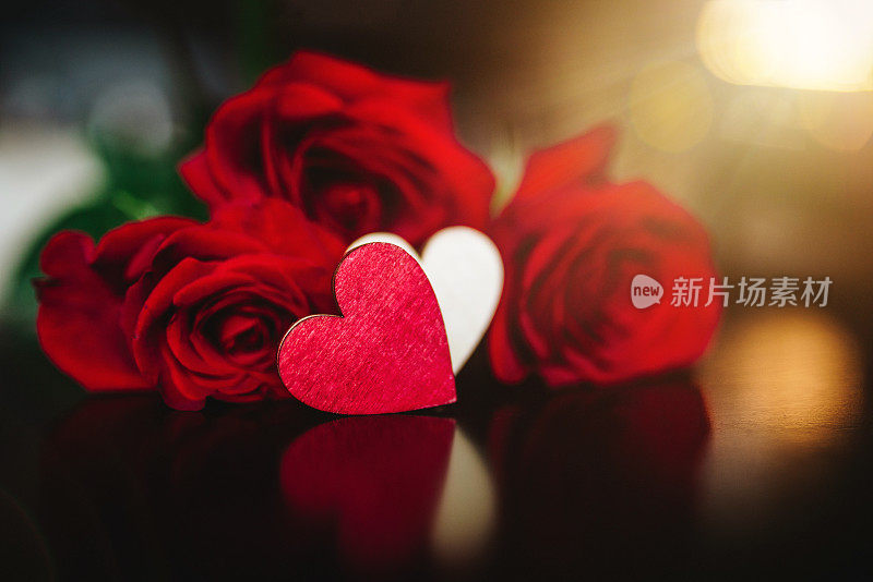 圣瓦伦丁的墙纸——一颗木制的心和一束被灯光环绕的玫瑰。浪漫/爱情的背景/概念。情人节庆祝概念。